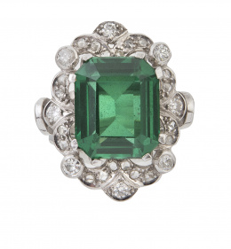 390.  Sortija con espinela verde sintética rodeada por diamantes en marco lobulado a distintas alturas, combinado con cuatro brillantes en chatones