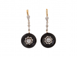 80.  Pendientes largos de pp. S. XX con brillante de talla antigua rodeado por marco de flor, sobre botón de ónix