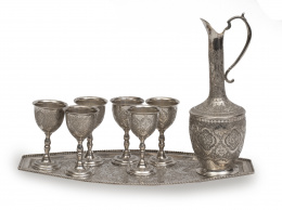 505.  Jarro con seis copas y bandeja de plata de profusa decoración grabada. Persia, Irán.