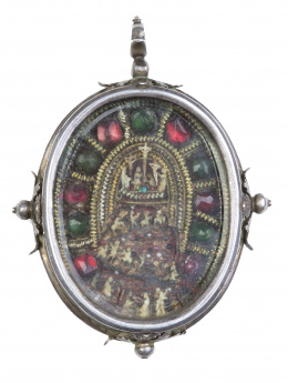772.  Medalla devocional con dos vitrales, por ambas caras escenas de la Crucifixión talladas y policromadas, enmarcadas por orla de cristales simulando piedras e hilos dorados y entorchados. Marco de plata con rosetas.Trabajo colonial?, S. XVIII.