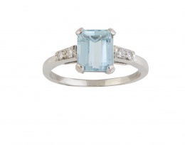 96.  Sortija con aguamarina talla esmeralda engastada en garras con parejas de brillantes en los brazos