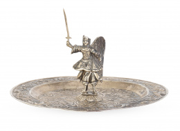 1410.  Plato limosnero o de demanda de plata repujada con decoración floral y San Miguel Arcángel en bulto redondoTrabajo peruano, S. XVIII.