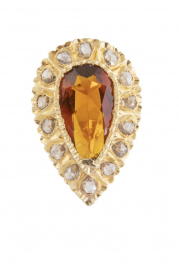 25.  Sortija con gran topácio color cognac talla perilla rodeada por marco de diamantes en oro labrado