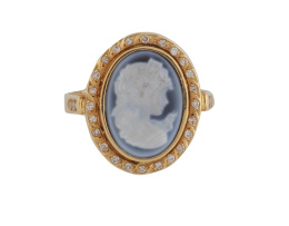 180.  Sortija oval con camafeo de busto de dama en ágata azul bicolor con marco de diamantes y trabajo grabado en oro