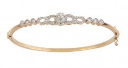 66.  Brazalete rígido de diamantes de pp. S. XX con frente calado donde se combinan dimantes en chatones con motivos calados, con diamante en garras central
