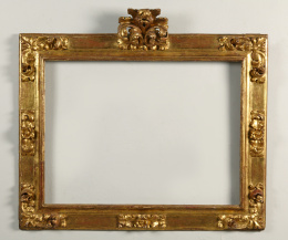 503.  Marco en madera tallada, estucada y dorada, con copete.Trabajo español, S. XVII..