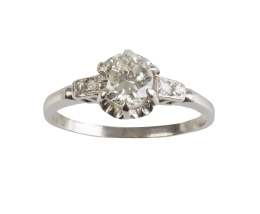 112.  Sortija solitario con brillante engastado en seis garras y flanqueado por diamantes en los brazos de la montura