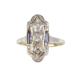 119.  Sortija lanzadera Art-Decó con frente lobulado en los extremos, con chatón de brillante central y zafiros talla baguette