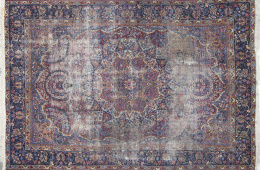 710.  Alfombra en lana de campo granate y azul con cartuchos, cenefa decorativa en azul con palmetas.Persia.