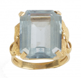 129.  Sortija años 50 con piedra azul de talla esmeralda en montura adornada por hojitas de oro mate