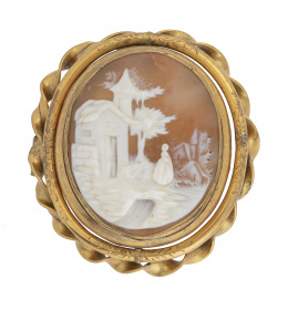16.  Broche guardapelo S. XIX con camafeo central en concha bicolor que representa paisaje con figura de dama