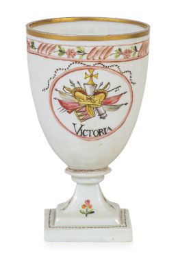 1049.  Copa conmemorativa de la Guerra de las Naranjas en opalina blanca soplada, esmaltada con motivos neoclásicos y trofeos militares, con las inscripciones “Victoria” y “Honor”Real Fábrica de Cristales de La Granja, periodo clasicista, ca. 1801