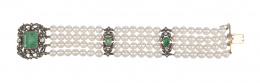 32.  Brazalete Isabelino con gran cierre de esmeralda y diamantes, y cuatro hilos de perlas unidos con entrepiezas de diamantes y esmeraldas