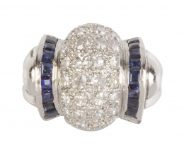 102.  Sortija chevaliere con centro bombée de pavé de brillantes entre arcos de zafiros calibrados