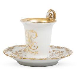 1151.  Taza de porcelana esmaltada y dorada decorada con iniciales y hojas.S. XIX.