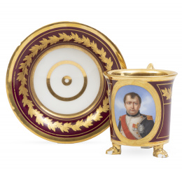 1154.  Taza de porcelana esmaltada y dorada a fuego, decorada con retrato de Napoleón con uniforme en reserva.Berlín, ff. del S. XIX.