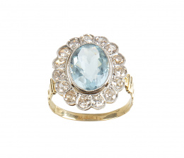 198.  Sortija años 30 con piedra azul oval orlada de brillantes de talla antigua, con perfil lobulado