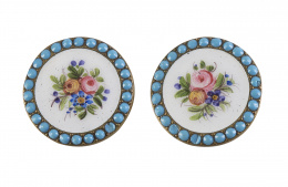 18.  Pareja de botones circulares de esmalte de pp. S. XX con flores policromadas sobre fondo blanco orladas de puntos de esmalte turquesa