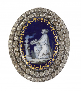 15.  Broche oval memento mori S. XVIII en esmalte azul con adornos de cadeneta de en oro en el contorno, representa escena de dama haciendo ofrenda