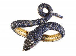 196.  Brazalete con diseño de serpiente competamente cuajado de cabuchones de zafiros, combinados con diamantes en cabeza y brillantes en el cuerpo, y ojos de rubíes