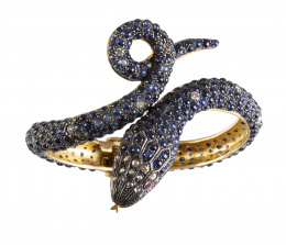 199.  Brazalete con diseño de serpiente completamente cuajado de cabuchones de zafiros, combinados con diamantes en cabeza y brillantes en el cuerpo, y ojos de rubíes