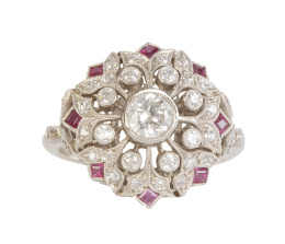 266.  Sortija rosetón de brillantes y rubíes estilo Art-Decó, con brillante central  de 0,40 ct aprox, y decoración calada