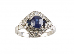 285.  Sortija con diseño de rombo con zafiro central de 0,89 ct aprox oval flanqueado por zafiros calibrados, con marco de brillantes
