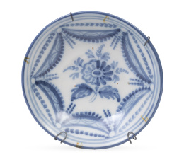 1033.  Plato acuencado de cerámica esmaltada en azul de cobalto decorado con pabellones.Talavera, S. XIX.