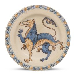 1213.  Plato de cerámica esmaltada de la serie polícroma, con león rampante en el asiento.Talavera, S. XVII.