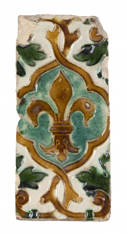 516.  Placa de techo con la técnica de arista esmaltado en verde y melado, con flor de lis.Triana, S. XVI.