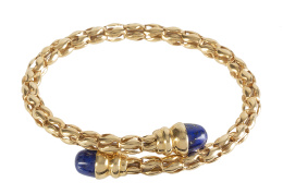374.  Brazalete flexible de oro tubular calado rematado con cabuchones de lapislázuli en frente de brazos abiertos