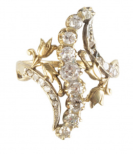 332.  Sortija lanzadera de pp. S. XX con línea sinuosa de brillantes de talla antigua flanqueada por flores de oro y bandas de diamantes 