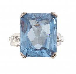 270.  Sortija con topacio azul de talla rectangular y parejas de brillantes en los brazos de la montura