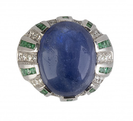 395.  Sortija bombée con gran zafiro oval central de 17,60 ct, rodeado de bandas de brillantes y esmeraldas calibradas alternas decorando la montura