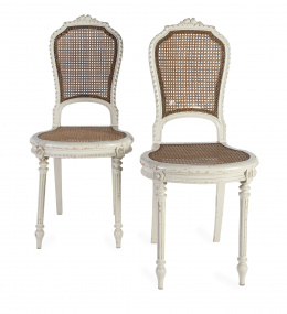 1311.  Pareja de sillas de estilo Luis XVI en madera policromada de blanco con asiento y respaldo de enea.Trabajo francés, pp. del S. XX.