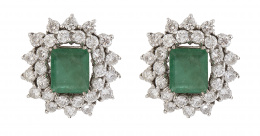 321.  Pendientes con esmeralda central talla esmeralda con doble orla de brillantes, la exterior de mayor tamaño