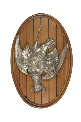 1172.  Perdiz decorativa de metal dorado, sobre panel de madera.Valentí, S. XX.