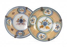 699.  Pareja de platos acuencados de cerámica esmaltada con flores y retícula en ocre.Talavera, S. XIX.