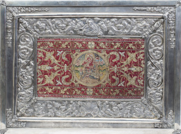 1104.  Marco de plata con alma de madera decorado con hojas, roleos, una concha y Dios Padre, España, S. XIX; el bordado de terciopelo rojo con hilos entorchados en oro y reserva con Santa Lucía, España, S. XVI.