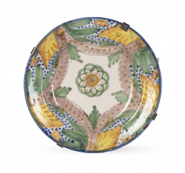 695.  Plato de cerámica esmaltada con flor en el asiento y trabajo de esponjado con pabellones en manganeso.Manises, S. XX.