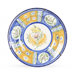 693.  Plato de cerámica esmaltada, con flor y cartelas en el alero con flores y decoración geométrica.Manises, S. XX.