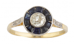 138.  Sortija ojo de perdiz con brillante central de 0,35 ct orlado de zafiros calibrados