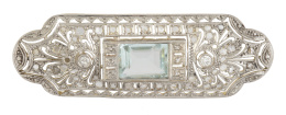 129.  Broche placa  Art-Decó con aguamarina talla esmeralda central, en decoración geométrica calada y cuajada de diamantes