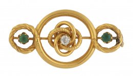 48.  Broche Victoriano S. XIX con diseño de nudo entre aros, con centro de brillante de talla antigua y dos esmeraldas laterales