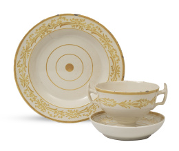 1060.  Lote de taza con platito y un plato de cerámica esmaltada de la serie del reflejo dorado, de la tercera época.Alcora, h. 1800-1825.