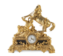 1154.  Reloj de metal dorado con caballo y personaje sobre el plinto.Francia, mediados del S. XIX.