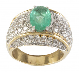 317.  Sortija ancha de con esmeralda oval central y pavé de brillantes en el frente y laterales de la montura