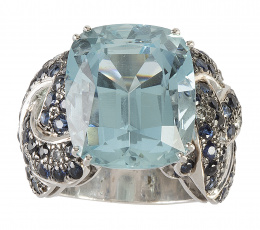 406.  Sortija con gran aguamarina central de intenso color en talla cojín, con montura de bandas trenzadas de zafiros adornadas con brillantes