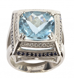 309.  Sortija con topacio azulcuadrangular en talla fantasía rodeado de un marco de brillantes y otro de zafiros 