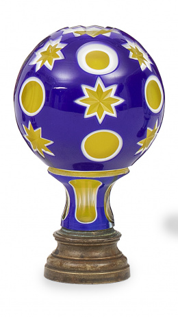 1351.  Remate de escalera de cristal azul y amarillo con opalina sobre base de metal, decorado con círculos y estrellas.pp. del S. XX.